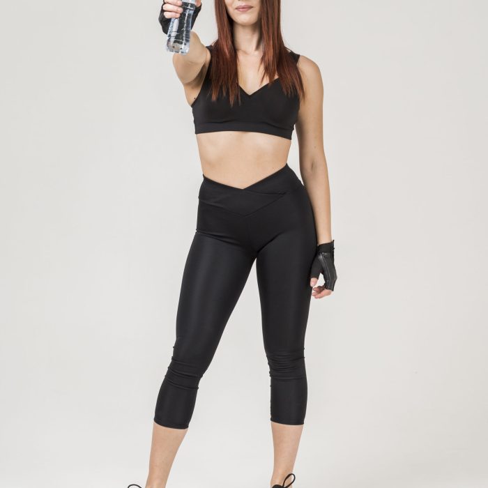 front-view-woman-gym-attire-posing-while-holding-up-bottle-water